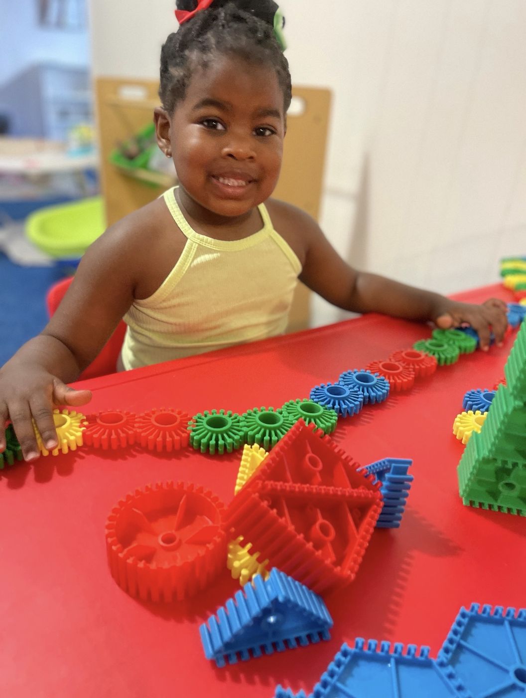 Toddler playing with colorful gear and block toys