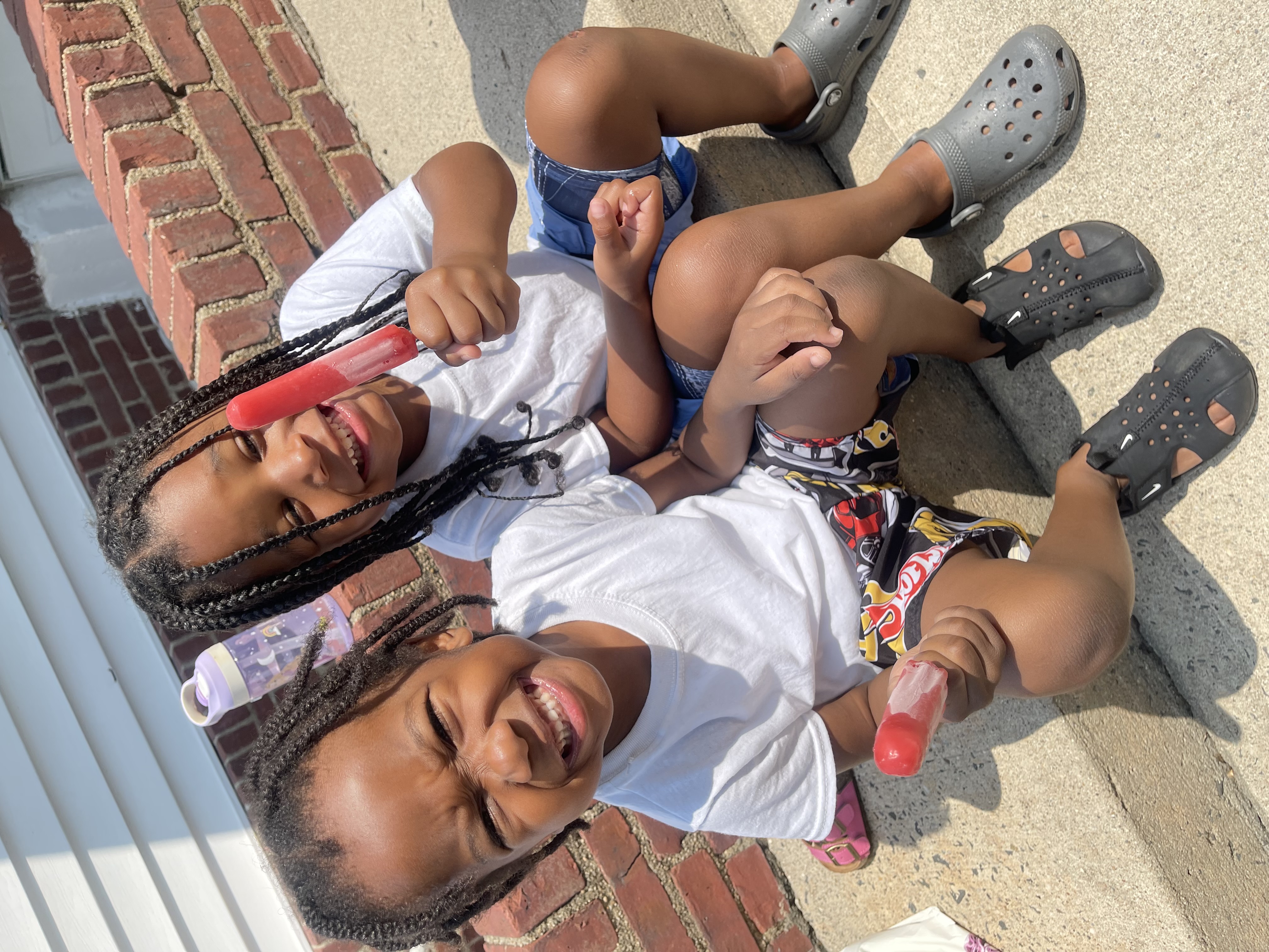 Two boys enjoying popsicles on the front steps